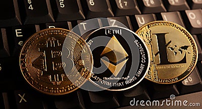 Bitcoin BTC, Ethereum ETH, Litecoin LTC coins over laptop keyboard Editorial Stock Photo