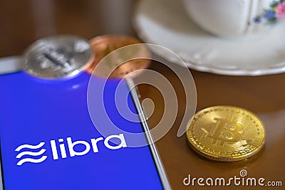 Bitcoin Coin with the Facebook`s Libra Crypto Coin logo Editorial Stock Photo