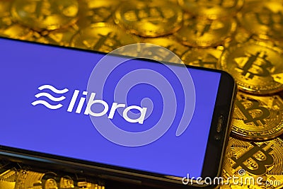 Bitcoin Coin with the Facebook`s Libra Crypto Coin logo Editorial Stock Photo