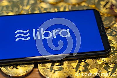 Bitcoin Coin with the Facebook`s Libra Crypto Coin logo Editorial Stock Photo