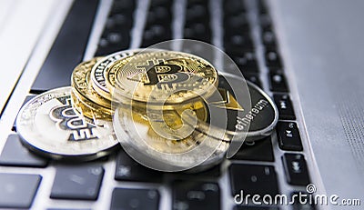 Bitcoin coin on a top of other crypto coins on a keyboard of laptop. Bitcoin golden coins. Cryptocurrency investment Editorial Stock Photo