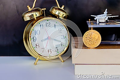 Bitcoin coins on book alarm clock old gold and model of passenger plane over white black background Stock Photo