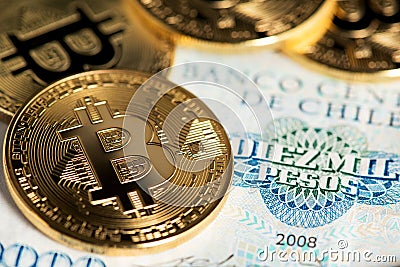 Bitcoin coins on Chilean banknote close up image. Bitcoin with Chilean pesos banknote. Stock Photo