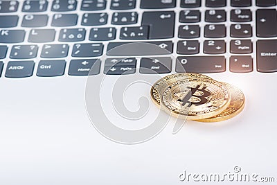 Bitcoin coins on a keyboard of white laptop. Computer. Investment situation. New virtual currency. Most valuable cryptocurrency Stock Photo