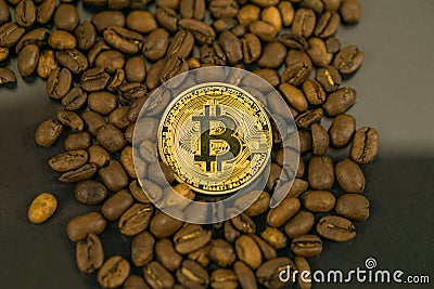 Bitcoin cryptocurrency coin as payment currency surrounded with coffee beans Stock Photo