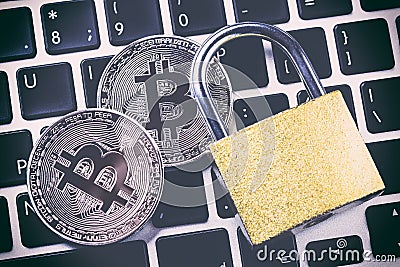 Bitcoin cryptocurrency with padlock on keyboard. Close up image Stock Photo