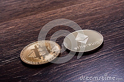 Bitcoin and Ethereum on a dark wooden surface Editorial Stock Photo