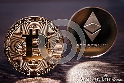 Bitcoin and Ethereum on a dark wooden surface Editorial Stock Photo