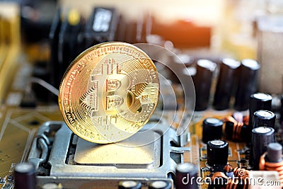 Bitcoin Gold is placed on the CPU processor in the socket and slot motherboard computer. Background, line graph, financial Stock Photo