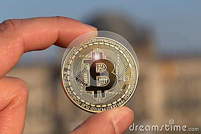 Bitcoin in a hand in front of a german bundestag Stock Photo