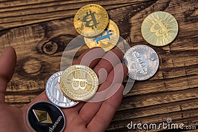 Bitcoin, litecoin and ethereum lie on mans hand closeup Editorial Stock Photo
