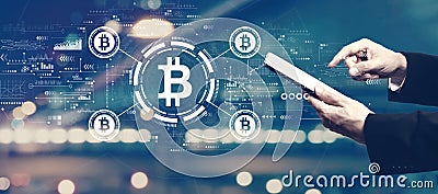 Bitcoin theme with businessman using a tablet Editorial Stock Photo