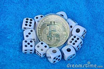 Bitcoin yellow coin and white game dice on blue wool Stock Photo