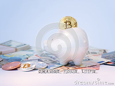 Bitcoins, New Virtual Money concept in piggy bank. Gold bitcoins with name Change Your Life on dollars ' euros ' background. Golde Stock Photo
