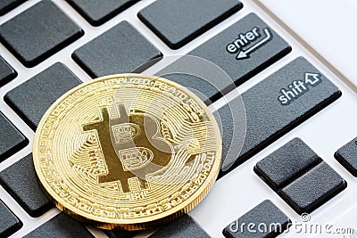 bitcoins placed on a black keyboard to see enter button in Crypt Stock Photo