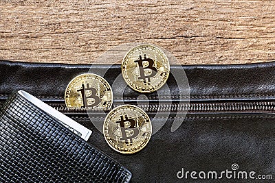 Bitcoins placed on the leather bag with the wallet on the wooden Stock Photo