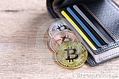Bitcoins placed into leather wallet on the wooden table. Virtual Stock Photo