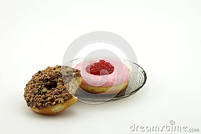 A bitten doughnuts and a dish of donuts Stock Photo