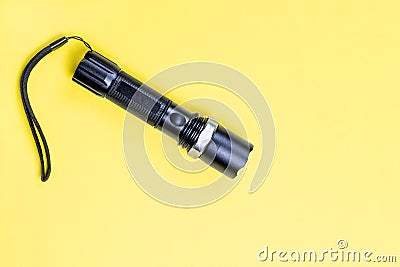 Blacc metal small tactical falshlight isoltaed on yellow background Stock Photo