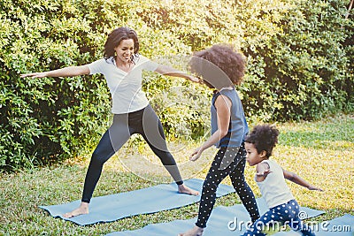 Black African American mom with child playing yoga family activity together at backyard during self quarantine at home Stock Photo