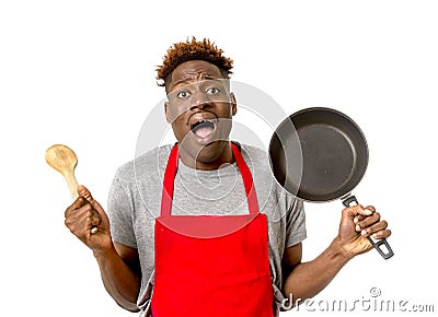 Black afro american man home cook in chef apron cooking pan and spoon lost and overworked Stock Photo