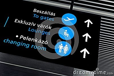 Black airport terminal sign with blue symbols Stock Photo