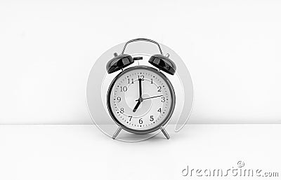 Black alarm clock on white wall background Stock Photo