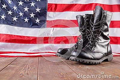 black ankle boots in front of US flag on wooden surface Stock Photo