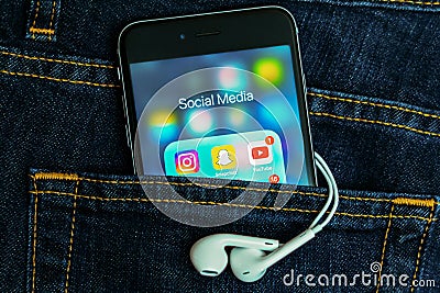 Black Apple iPhone with icons of social media application on screen with denim jeans background. Editorial Stock Photo