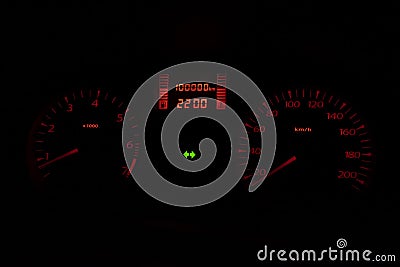 Black automobile dashboard with orange lights of odometer and green emergency lights Stock Photo