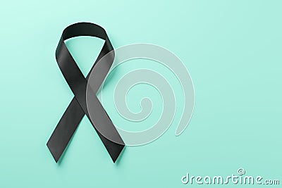 Black awareness ribbon on blue background. Mourning and melanoma symbol Stock Photo