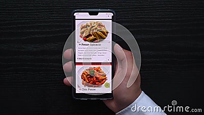 Black background on which you can see the hand that makes an order via the online store using a mobile device, ordering I write wi Editorial Stock Photo