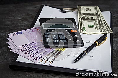 Ballpoint pen with a bunch of euros, dollars and a calculator Stock Photo