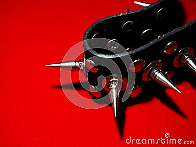 Black bdsm collar with metal spikes on a red background Stock Photo