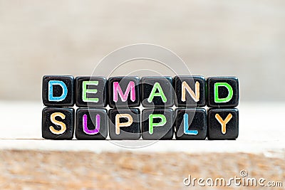 Black bead with letter in word demand supply on wood background Stock Photo