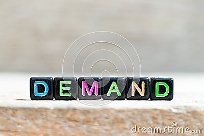 Black bead with letter in word demand on wood background Stock Photo