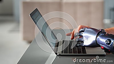 Black bio limb prothesis and healthy hand appear over laptop and type on keyboard under bright sunlight Stock Photo