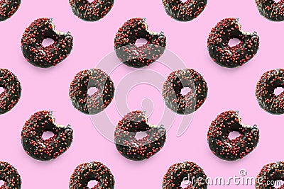 Black bited donuts with red glaze on pink background seamless pattern top view. Food dessert flatly flat lay of Stock Photo