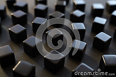 Black blocks on a dark background. Scattered cubes. Abstraction, field blur. Simplicity and elegance. Stock Photo