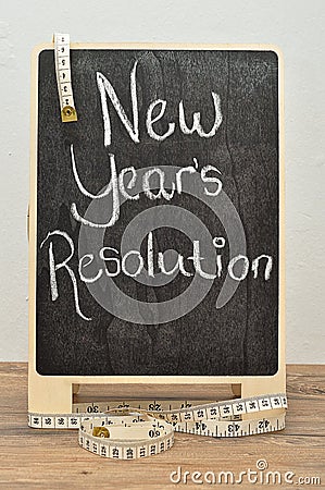 A black board with the words new years resolution and a measuring tape Stock Photo