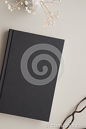Black book mockup with a dried gypsophila decoration on a beige table Stock Photo