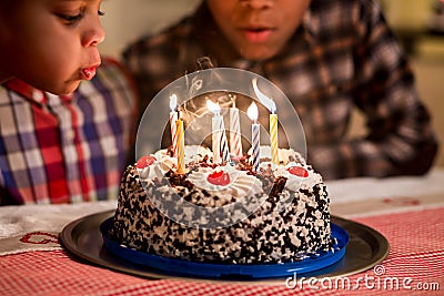 Black boys blow candles out. Stock Photo