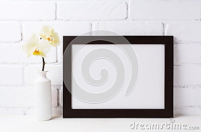 Black brown landscape frame mockup with soft yellow orchid in v Stock Photo