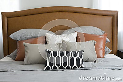 Pillows setting on bed with brown leather headboard Stock Photo