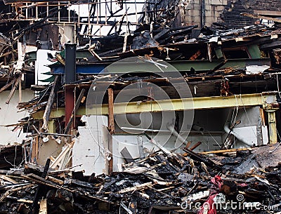 Black burned debris timber and steel beams in a collapsed building destroyed by fire Stock Photo