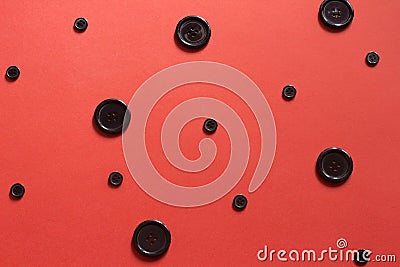 Black buttons polka dot on red paper background Stock Photo