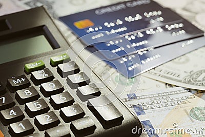 Black calculator reflect with sun light in the evening on pile of credit cards and US Dollar bills money using as debt crisis, Stock Photo