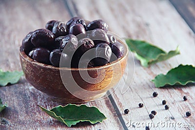 Black canned olives in a wooden plate Stock Photo