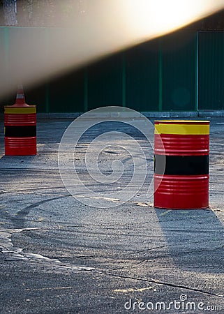 Black car tire skid track on asphalt road track. Tin barrels of red, black, yellow color Stock Photo