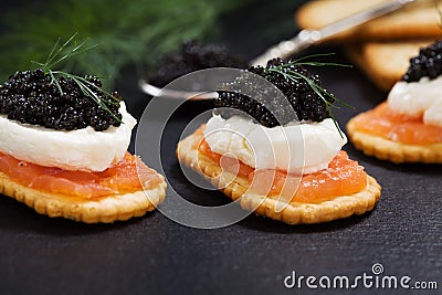 Black caviar served on crackers with salmon and cream cheese Stock Photo